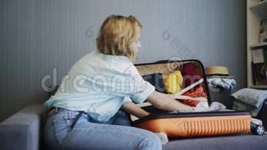 旅行妇女坐在沙发和行李箱边的侧视图准备上路